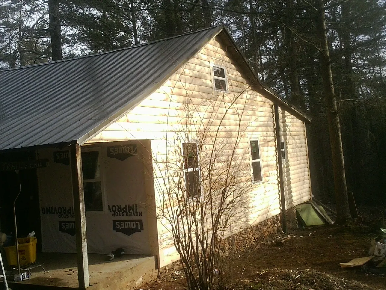 Log siding gable end under a dark metal roof edge in Bretton Woods