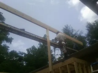 Carpenter setting a ridge beam over a new addition frame — Ice Dam Removal by Roofing Brothers in Bretton Woods
