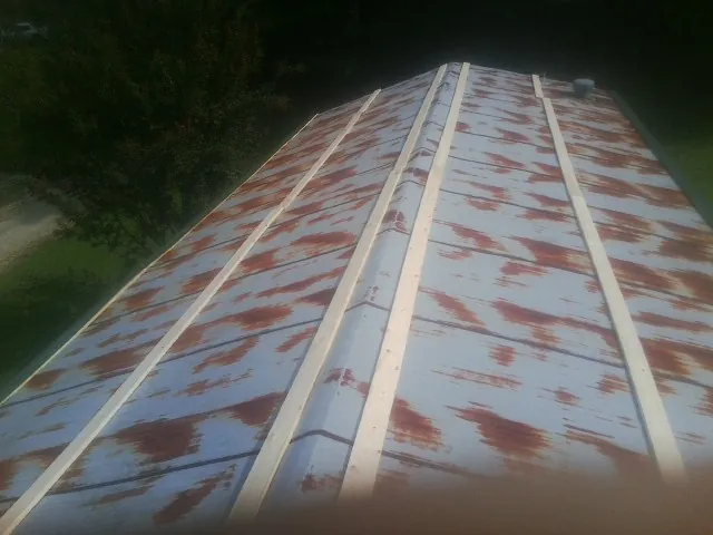 Rusted metal roof panels with new wood purlins before replacement — Storm Damage Roof Repair in Bretton Woods by Roofing Brothers