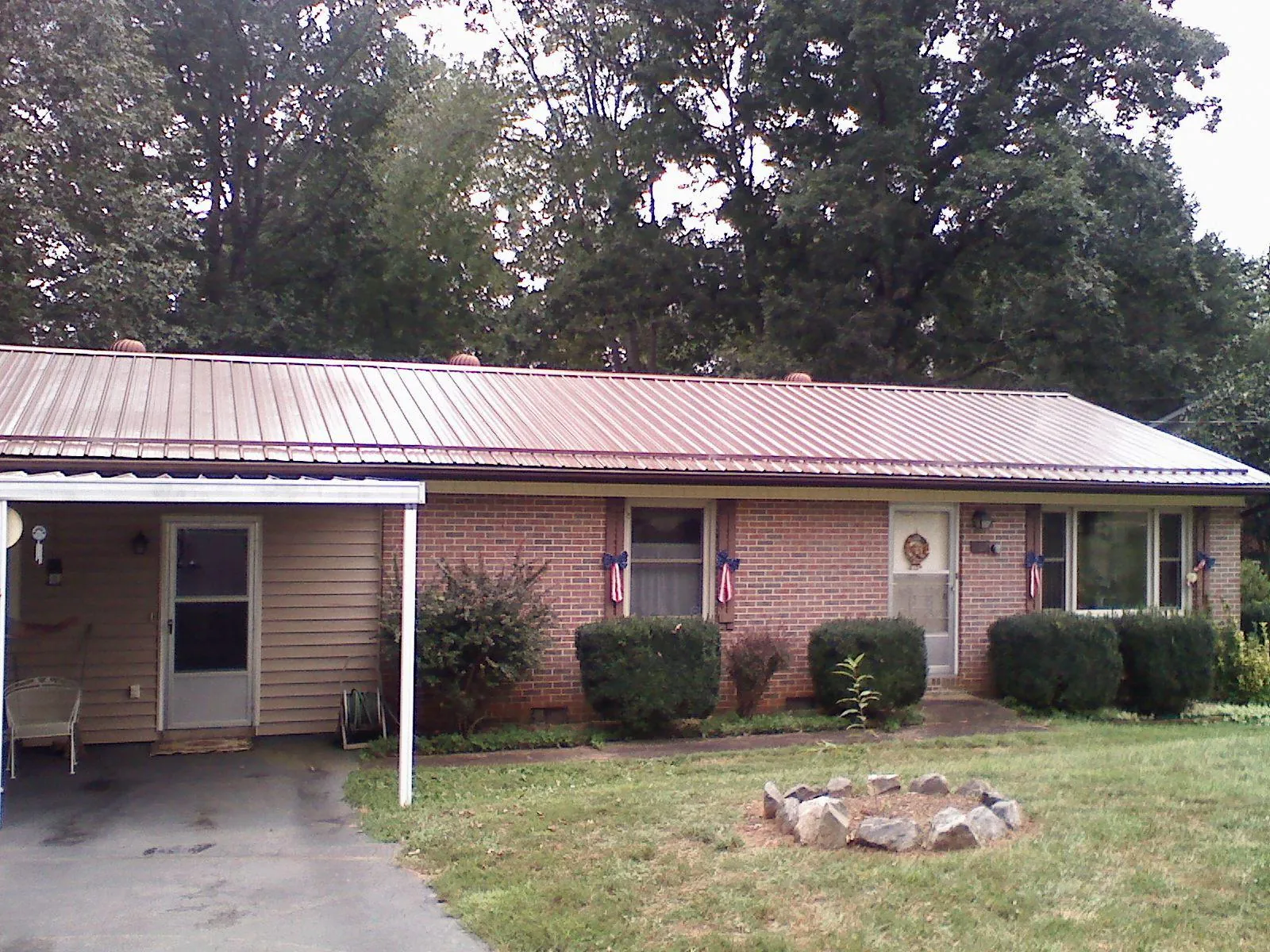 Bronze metal roof and carport on a brick ranch home — Roof Repair work by our crew in Bretton Woods